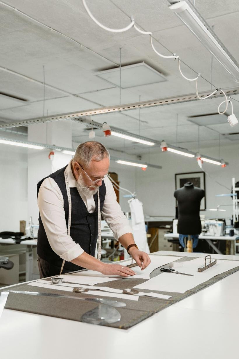 A person in a factory desighning a pattren of sports uniforms.